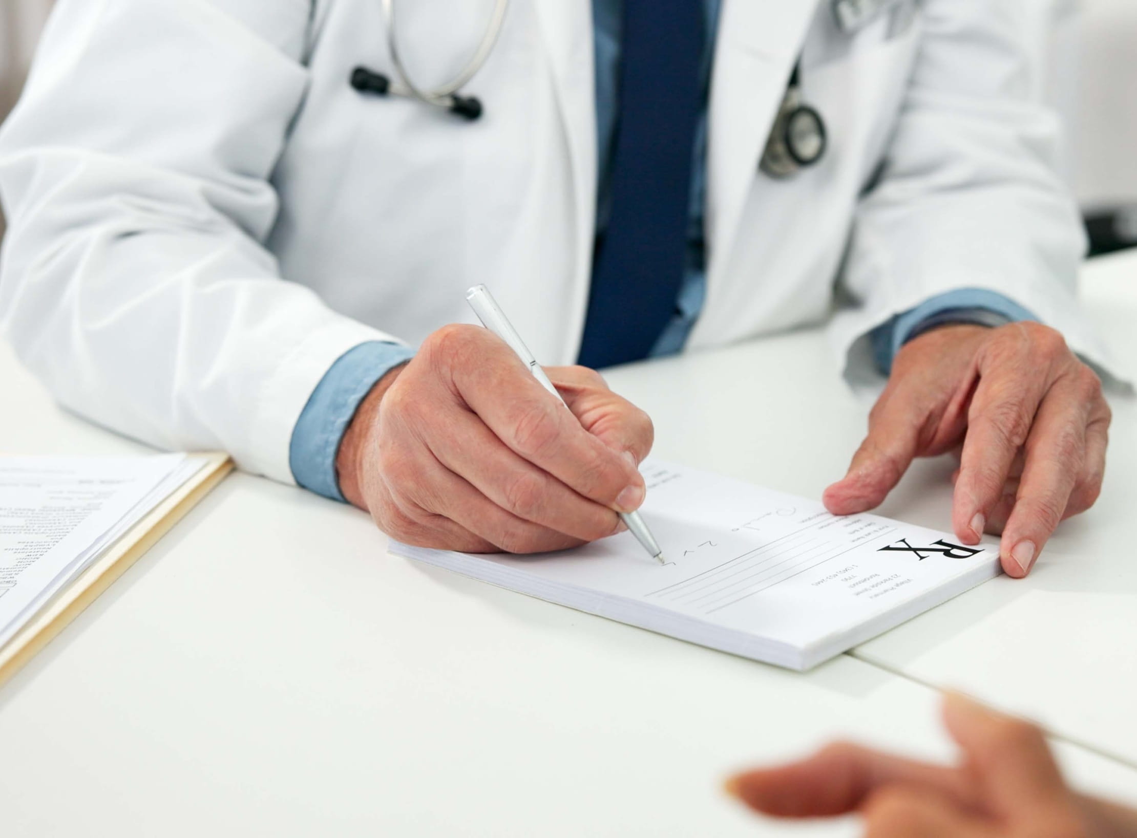 Male Doctor is Writing Medical Prescription